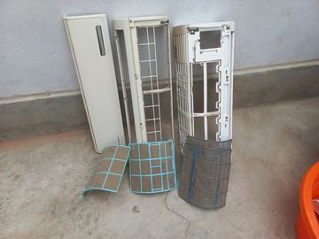 Tampa, grelha e filtros de uma unidade interior desmontada para limpeza