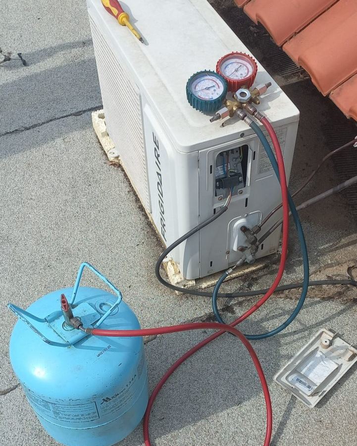 Manómetros ligados a uma unidade exterior Frigidaire e a uma garrafa de gás refrigerante