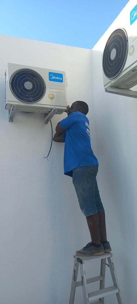 Técnico da Cruz Clima a apertar as ligações de uma unidade exterior Midea acabada de instalar
